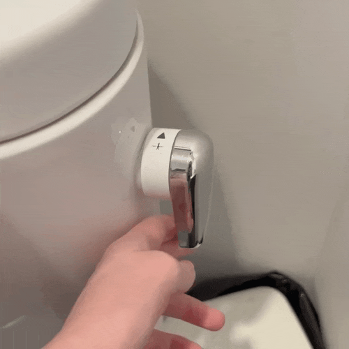 Rotating the flush handle in the 大 (big flush) direction